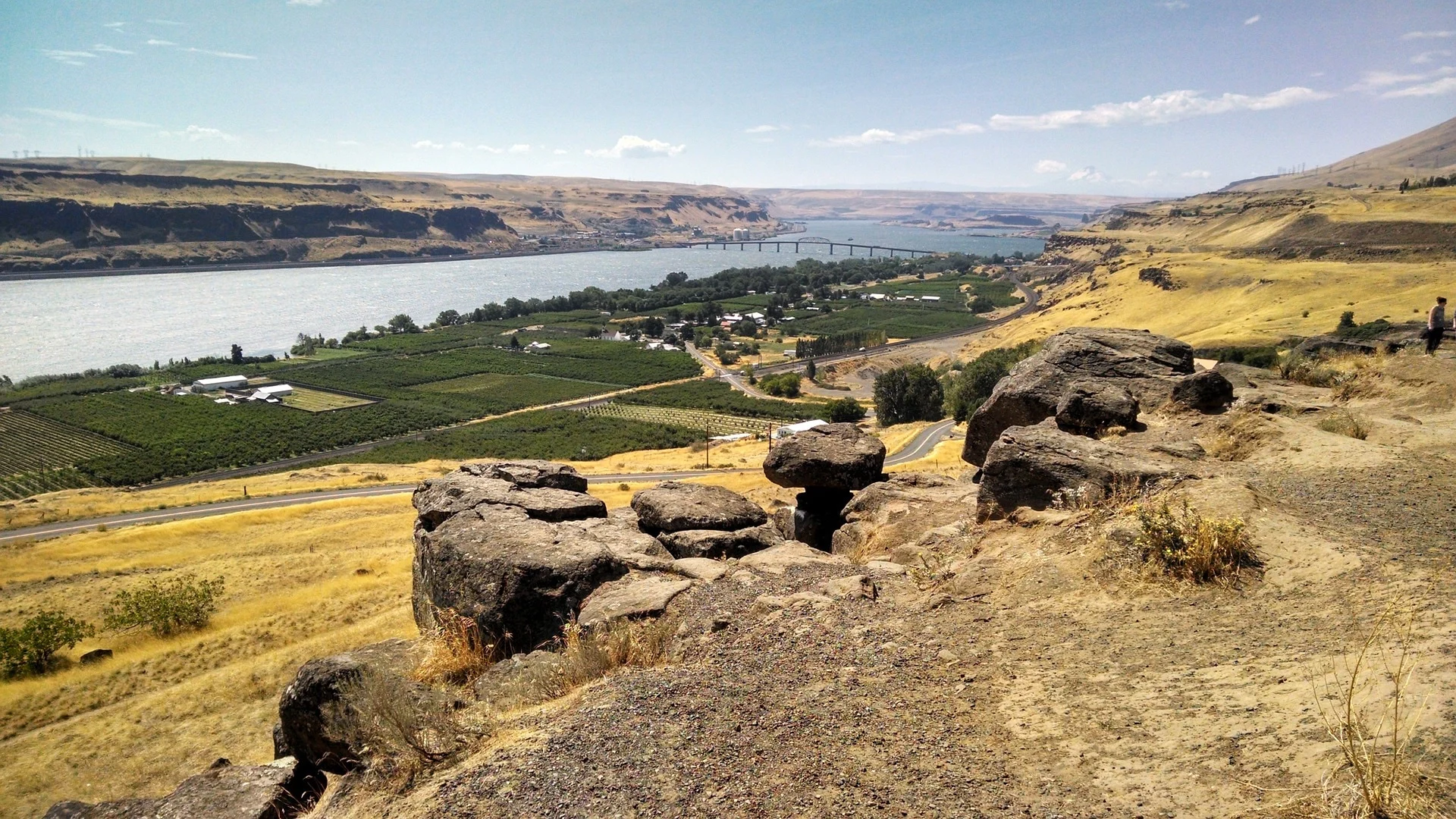 A quiet river valley framed by rocky hills